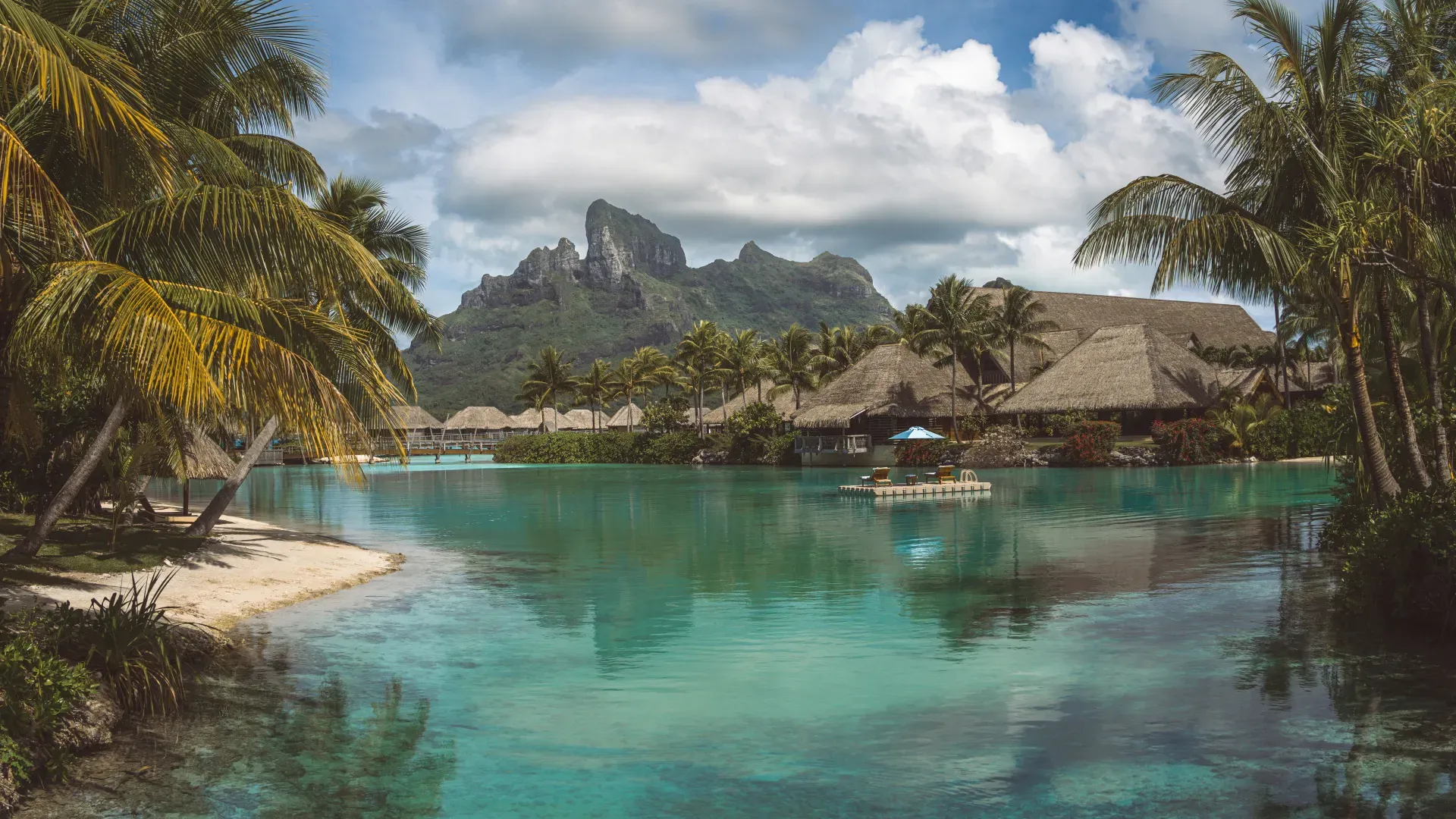 Overwater bungalows and turquoise lagoon in Bora Bora with Mount Otemanu in the background