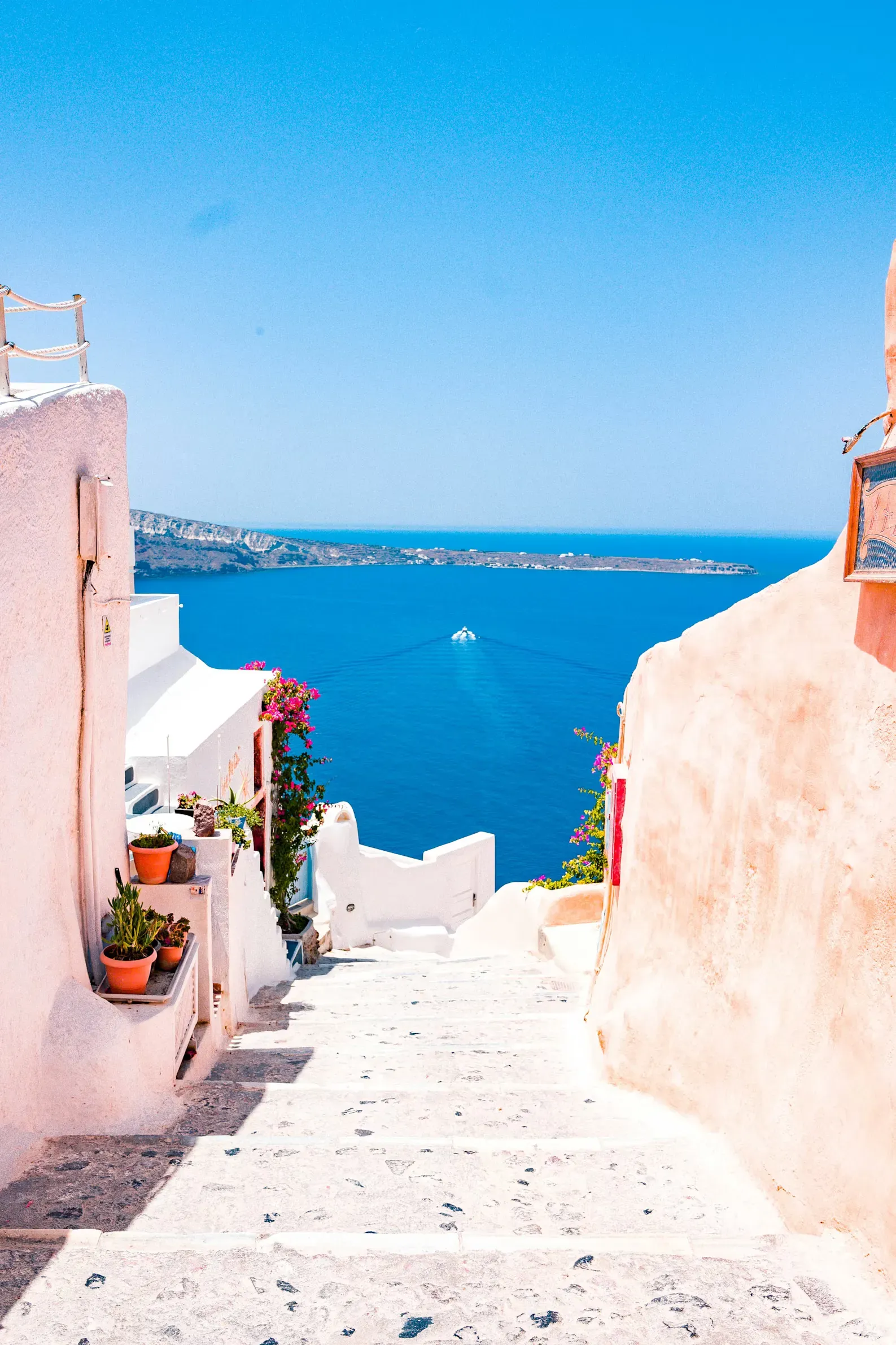 Sun-bleached steps leading down to the blue Aegean Sea in Santorini, Greece